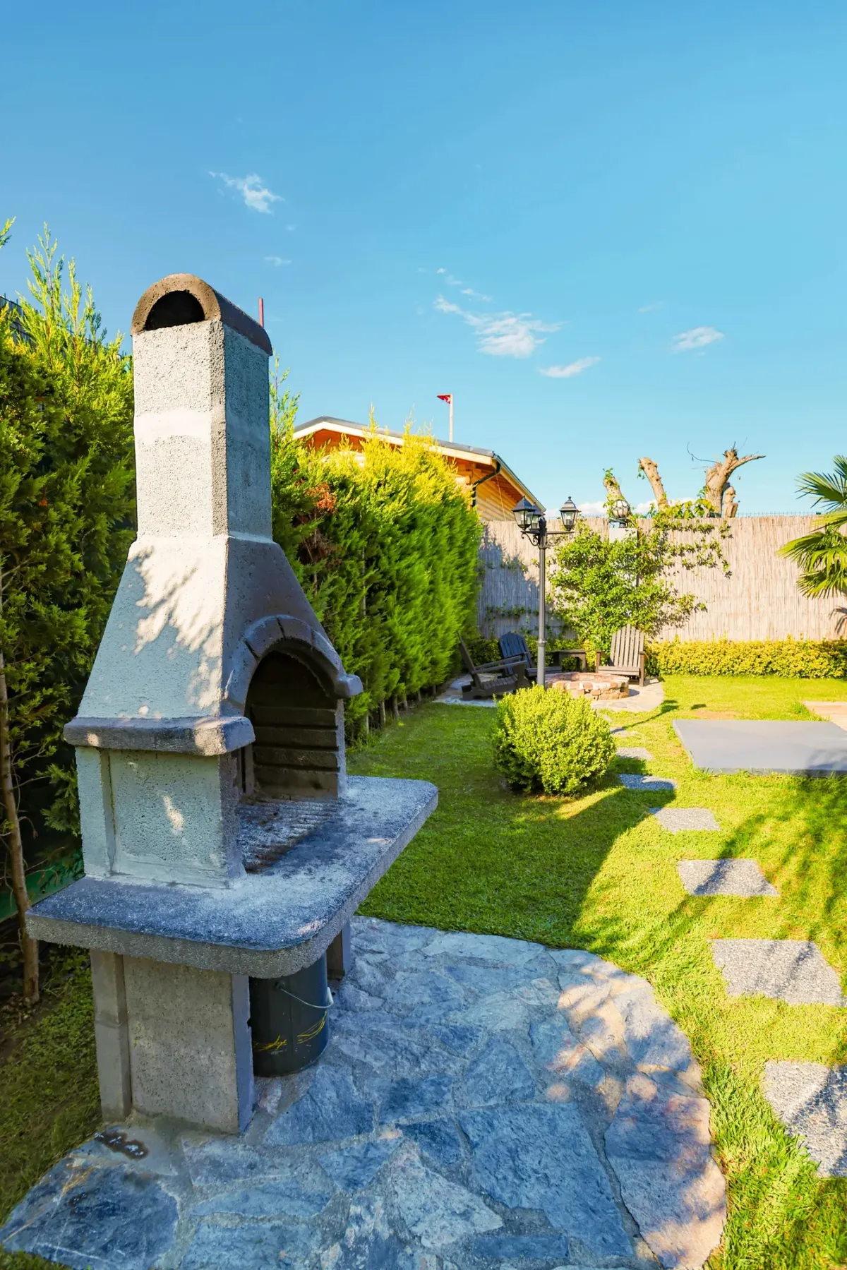 Bahçede taştan örülmüş barbekü ocağı, yanında ahşap tezgah